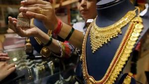 A saleswoman shows a gold earring to customers at a jewellery showroom in Mumbai.(Reuters File Photo) A saleswoman shows a gold earring to customers at a jewellery showroom in Mumbai.(Reuters File Photo)