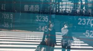 People wearing protective face masks, following an outbreak of the coronavirus, are reflected on a screen showing Nikkei index, outside a brokerage in Tokyo, Japan(Reuters File Photo) People wearing protective face masks, following an outbreak of the coronavirus, are reflected on a screen showing Nikkei index, outside a brokerage in Tokyo, Japan(Reuters File Photo)