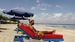A tourist wearing facemask sunbathes as beaches are gradually reopening following months of lockdown due to the new coronavirus outbreak, in Bali, Indonesia.(AP) A tourist wearing facemask sunbathes as beaches are gradually reopening following months of lockdown due to the new coronavirus outbreak, in Bali, Indonesia.(AP)