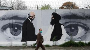 An Afghan man wearing a protective face mask walks past a wall painted with photo of Zalmay Khalilzad, U.S. envoy for peace in Afghanistan, and Mullah Abdul Ghani Baradar, the leader of the Taliban delegation, in Kabul, Afghanistan.(REUTERS) An Afghan man wearing a protective face mask walks past a wall painted with photo of Zalmay Khalilzad, U.S. envoy for peace in Afghanistan, and Mullah Abdul Ghani Baradar, the leader of the Taliban delegation, in Kabul, Afghanistan.(REUTERS)