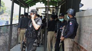 Police officers gather at an entry gate of district court following the killing of Tahir Shamim Ahmad, who was in court accused of insulting Islam, in Peshawar, Pakistan.(AP) Police officers gather at an entry gate of district court following the killing of Tahir Shamim Ahmad, who was in court accused of insulting Islam, in Peshawar, Pakistan.(AP)