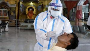 A healthcare worker wearing personal protective equipment takes a swab from a man to test for Covid-19 in Ahmedabad, Gujarat.(ANI File) A healthcare worker wearing personal protective equipment takes a swab from a man to test for Covid-19 in Ahmedabad, Gujarat.(ANI File)