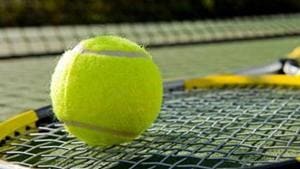A tennis racket and new tennis ball on a freshly painted tennis court A tennis racket and new tennis ball on a freshly painted tennis court