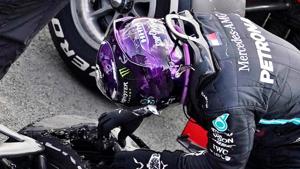 Formula One F1 - British Grand Prix - Silverstone Circuit, Silverstone, Britain - August 2, 2020 Mercedes' Lewis Hamilton looks at his tyre after winning the race with a puncture on the final lap Pool via REUTERS/Will Oliver(Pool via REUTERS) Formula One F1 - British Grand Prix - Silverstone Circuit, Silverstone, Britain - August 2, 2020 Mercedes' Lewis Hamilton looks at his tyre after winning the race with a puncture on the final lap Pool via REUTERS/Will Oliver(Pool via REUTERS)