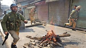 Policemen run near road blockades set up by protesters in Srinagar on October 29, 2019.(Waseem Andrabi/ht) Policemen run near road blockades set up by protesters in Srinagar on October 29, 2019.(Waseem Andrabi/ht)