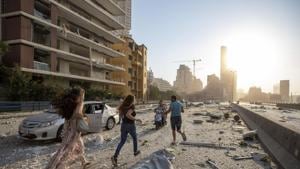People run in the aftermath of a massive explosion in Beirut, Lebanon.(AP) People run in the aftermath of a massive explosion in Beirut, Lebanon.(AP)
