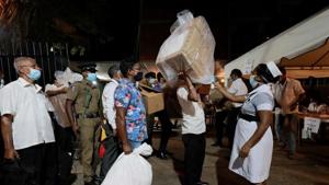 A health official takes the temperature of election officials who arrive with ballot boxes from a polling station to a counting center, after the voting ended during the country's parliamentary election in Colombo, Sri Lanka.(Reuters) A health official takes the temperature of election officials who arrive with ballot boxes from a polling station to a counting center, after the voting ended during the country's parliamentary election in Colombo, Sri Lanka.(Reuters)