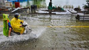 A motorist rides through a waterlogged road near the swollen Masunda Lake following incessant rains, in Thane on August 6, 2020.(PTI Photo) A motorist rides through a waterlogged road near the swollen Masunda Lake following incessant rains, in Thane on August 6, 2020.(PTI Photo)