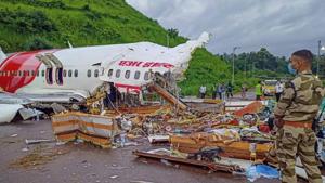 A security person stands guard near the mangled remains of an Air India Express flight, en route from Dubai, after it skidded off the runway while landing on Friday night, at Karippur in Kozhikode on Saturday.(PTI Photo) A security person stands guard near the mangled remains of an Air India Express flight, en route from Dubai, after it skidded off the runway while landing on Friday night, at Karippur in Kozhikode on Saturday.(PTI Photo)