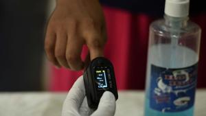 A health worker examines the oxygen saturation levels of a local resident using a pulse oximeter before swab samples collection for coronavirus testing at Sukhrali Enclave near Shiv temple in Gurugram.(Parveen Kumar/HT Photo) A health worker examines the oxygen saturation levels of a local resident using a pulse oximeter before swab samples collection for coronavirus testing at Sukhrali Enclave near Shiv temple in Gurugram.(Parveen Kumar/HT Photo)