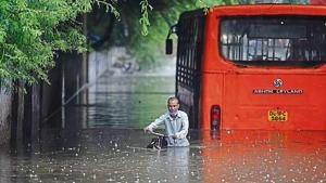 A cyclist makes his way while a bus is seen partially submerged at Zakhira underpass. A cyclist makes his way while a bus is seen partially submerged at Zakhira underpass.