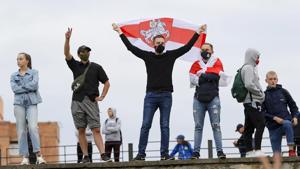 People with old Belarusian National flag gather in a street protesting the election results in Minsk.(AP) People with old Belarusian National flag gather in a street protesting the election results in Minsk.(AP)