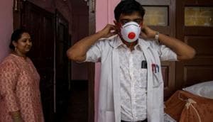 Dr. Kumar Gaurav, 42, a medical professor and consultant psychiatrist who has been named the top official at Jawahar Lal Nehru Medical College and Hospital during the coronavirus disease (Covid-19) outbreak, puts on his personal protective equipment (PPE) as his wife Dr. Mili Jaswal, a psychologist, looks on, at their home in Bhagalpur, Bihar, India.(Reuters photo) Dr. Kumar Gaurav, 42, a medical professor and consultant psychiatrist who has been named the top official at Jawahar Lal Nehru Medical College and Hospital during the coronavirus disease (Covid-19) outbreak, puts on his personal protective equipment (PPE) as his wife Dr. Mili Jaswal, a psychologist, looks on, at their home in Bhagalpur, Bihar, India.(Reuters photo)