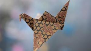 An origami paper crane hangs in the Matter Studio Gallery in Los Angeles, among thousands of others during an exhibit for those who have died in the U.S., of COVID-19, on Tuesday, Aug. 11, 2020.(AP Photo/Richard Vogel) An origami paper crane hangs in the Matter Studio Gallery in Los Angeles, among thousands of others during an exhibit for those who have died in the U.S., of COVID-19, on Tuesday, Aug. 11, 2020.(AP Photo/Richard Vogel)