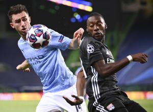 Manchester City's Aymeric Laporte, left, and Lyon's Karl Toko Ekambi battle for the ball during the Champions League quarterfinal match between Manchester City and Lyon at the Jose Alvalade stadium in Lisbon, Portugal, Saturday, Aug. 15, 2020. (Franck Fife/Pool Photo via AP)(AP)