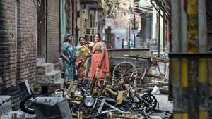 Women stand beside charred remains of vehicles and vandalised properties at Shiv Vihar in Northeast Delhi.(PTI) Women stand beside charred remains of vehicles and vandalised properties at Shiv Vihar in Northeast Delhi.(PTI)