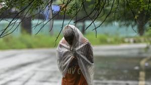 A man uses a plastic sheet for cover himself from rain, at Nizamuddin, in New Delhi.(Biplov Bhuyan/HT PHOTO) A man uses a plastic sheet for cover himself from rain, at Nizamuddin, in New Delhi.(Biplov Bhuyan/HT PHOTO)