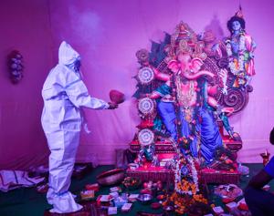 Kolkata: A devotee wearing a PPE kit offers prayers at a community puja pandal on the occasion of Ganesh Chaturthi festival, amid the ongoing coronavirus pandemic, in Kolkata, Saturday, Aug. 22, 2020. (PTI) Kolkata: A devotee wearing a PPE kit offers prayers at a community puja pandal on the occasion of Ganesh Chaturthi festival, amid the ongoing coronavirus pandemic, in Kolkata, Saturday, Aug. 22, 2020. (PTI)