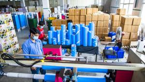 A worker wearing a protective mask operates a tape cutting machine while producing adhesive sealing tapes at a factory in Sonipat district, Haryana.(Bloomberg File Photo) A worker wearing a protective mask operates a tape cutting machine while producing adhesive sealing tapes at a factory in Sonipat district, Haryana.(Bloomberg File Photo)
