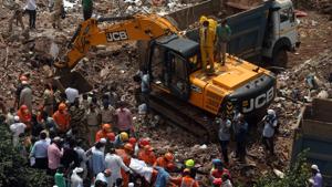 NDRF personnel rescue people from the debris after a five-storey building collapsed in Mahad, in Maharashtra’s Raigad district.(Reuters Photo) NDRF personnel rescue people from the debris after a five-storey building collapsed in Mahad, in Maharashtra’s Raigad district.(Reuters Photo)