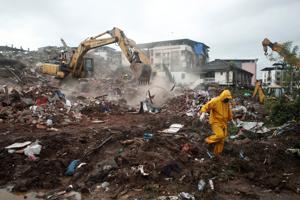 Rescue workers search for survivors in the debris after a five-storey building collapsed in Raigad district of Maharashtra.(REUTERS) Rescue workers search for survivors in the debris after a five-storey building collapsed in Raigad district of Maharashtra.(REUTERS)