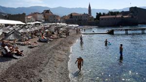 Tourists enjoy the beach in the coastal town of Budva, one of the major tourist spots at Montenegro's Adriatic coast, on August 17, 2020.(SAVO PRELEVIC / AFP) Tourists enjoy the beach in the coastal town of Budva, one of the major tourist spots at Montenegro's Adriatic coast, on August 17, 2020.(SAVO PRELEVIC / AFP)