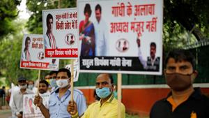 Supporters of the Congress hold placards as they gather outside party headquarters to demand the election of one of the Gandhis as the party’s president.(REUTERS) Supporters of the Congress hold placards as they gather outside party headquarters to demand the election of one of the Gandhis as the party’s president.(REUTERS)