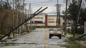 A Louisiana National Guard humble drives past utility poles damaged after Hurricane Laura made landfall in Lake Charles, Louisiana, US.(Bloomberg) A Louisiana National Guard humble drives past utility poles damaged after Hurricane Laura made landfall in Lake Charles, Louisiana, US.(Bloomberg)