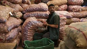 A man sorts onions at a vegetable wholesale market in Mumbai, India.(REUTERS) A man sorts onions at a vegetable wholesale market in Mumbai, India.(REUTERS)