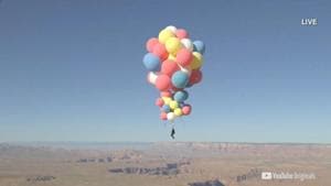 David Blaine hangs with a parachute under a cluster of balloons during a stunt to fly thousands of feet into the air.(via REUTERS) David Blaine hangs with a parachute under a cluster of balloons during a stunt to fly thousands of feet into the air.(via REUTERS)