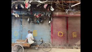 Two rickshaw pullers enjoying a tête-à-tête in Old Delhi’s Chatta Sheikh Mangloo against a backdrop of shuttered store fronts marked with O and E, indicating the opening of shops in markets on an odd-even basis during the waning days of the full lockdown in the capital during the month of May. (Mayank Austen Soofi / HT) Two rickshaw pullers enjoying a tête-à-tête in Old Delhi’s Chatta Sheikh Mangloo against a backdrop of shuttered store fronts marked with O and E, indicating the opening of shops in markets on an odd-even basis during the waning days of the full lockdown in the capital during the month of May. (Mayank Austen Soofi / HT)
