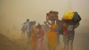 Migrant workers walking towards Farrukhabad and Sultanpur pause during a sudden dust storm, along NH24 near Indirapuram in New Delhi on May 10, 2020.(Ajay Aggarwal /HT PHOTO) Migrant workers walking towards Farrukhabad and Sultanpur pause during a sudden dust storm, along NH24 near Indirapuram in New Delhi on May 10, 2020.(Ajay Aggarwal /HT PHOTO)