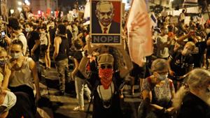 A protester holds a placard as he takes part in ongoing anti-government demonstrations near the prime minister's residence in Jerusalem, on September 5, 2020.(AFP photo) A protester holds a placard as he takes part in ongoing anti-government demonstrations near the prime minister's residence in Jerusalem, on September 5, 2020.(AFP photo)
