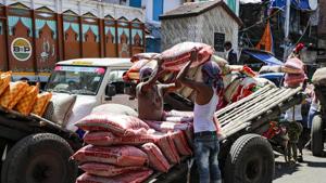 Laborers carry sacks of food grains at a market area in Kolkata, India. India’s economy has suffered its worst slump on record in April-June quarter of 2020-21.(AP)