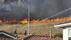 Firefighters protect homes and contain a 50-acre blaze in open space in San Luis Obispo, California.(AP) Firefighters protect homes and contain a 50-acre blaze in open space in San Luis Obispo, California.(AP)