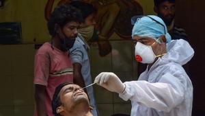 A health worker takes samples from a homeless man for Covid-19 test as others wait for their turn, in New Delhi.(PTI) A health worker takes samples from a homeless man for Covid-19 test as others wait for their turn, in New Delhi.(PTI)