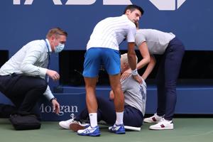 Novak Djokovic of Serbia tends to a line judge who was hit with the ball during his Men's Singles fourth round match against Pablo Carreno Busta of Spain on Day Seven of the 2020 US Open.(AFP) Novak Djokovic of Serbia tends to a line judge who was hit with the ball during his Men's Singles fourth round match against Pablo Carreno Busta of Spain on Day Seven of the 2020 US Open.(AFP)