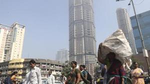 Indian walks past an under construction building in Mumbai.(AP) Indian walks past an under construction building in Mumbai.(AP)
