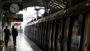 Passengers walk past a Delhi Metro Rail Corp. train sitting at a station platform during the resumption of services in New Delhi.(Bloomberg) Passengers walk past a Delhi Metro Rail Corp. train sitting at a station platform during the resumption of services in New Delhi.(Bloomberg)