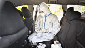 A health worker in PPE coveralls gears up to collect swab samples for Covid-19 testing inside a mobile collection van in New Delhi.(Sanchit Khanna/HT PHOTO) A health worker in PPE coveralls gears up to collect swab samples for Covid-19 testing inside a mobile collection van in New Delhi.(Sanchit Khanna/HT PHOTO)