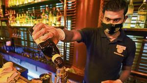 A bartender inside a restrobar at Connaught Place on Thursday, a day after Delhi government allowed them to open .(HT photo) A bartender inside a restrobar at Connaught Place on Thursday, a day after Delhi government allowed them to open .(HT photo)