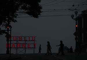 Wildfire smoke obscures the view of Elliott Bay as people walk by a Pike Place Market sign in Seattle, Washington(AFP) Wildfire smoke obscures the view of Elliott Bay as people walk by a Pike Place Market sign in Seattle, Washington(AFP)