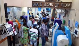 People crowd at the entrance of a State Bank of India branch while waiting to make transactions, at Laxmi Nagar, in New Delhi (Photo by Raj K Raj/ Hindustan Times) People crowd at the entrance of a State Bank of India branch while waiting to make transactions, at Laxmi Nagar, in New Delhi (Photo by Raj K Raj/ Hindustan Times)