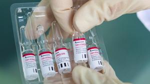 An employee demonstrates vials with An employee demonstrates vials with
