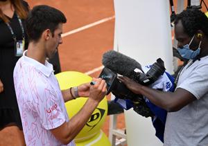 Tennis - ATP Masters 1000 - Italian Open - Foro Italico, Rome, Italy - September 19, 2020 Serbia's Novak Djokovic signs his autograph on a camera after winning his quarter final match against Germany's Dominik Koepfer Pool via REUTERS/Riccardo Antimiani(REUTERS) Tennis - ATP Masters 1000 - Italian Open - Foro Italico, Rome, Italy - September 19, 2020 Serbia's Novak Djokovic signs his autograph on a camera after winning his quarter final match against Germany's Dominik Koepfer Pool via REUTERS/Riccardo Antimiani(REUTERS)