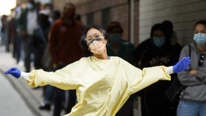 A health care worker poses for a photograph while walking towards a line of patients waiting outside a Covid-19 testing center at St. Michael's Hospital in Toronto, Ontario, Canada, on Sept. 18.(BlOOMBERG) A health care worker poses for a photograph while walking towards a line of patients waiting outside a Covid-19 testing center at St. Michael's Hospital in Toronto, Ontario, Canada, on Sept. 18.(BlOOMBERG)