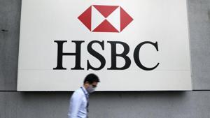 A man wearing a protective mask walks past a logo of HSBC at its headquarters.(Reuters) A man wearing a protective mask walks past a logo of HSBC at its headquarters.(Reuters)