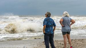 Steve and Linda Buser of Beaumont check out the rough surf on the beach near the intersection of Highway 124 and Highway 87 on the Bolivar Peninsula, Texas.(AP) Steve and Linda Buser of Beaumont check out the rough surf on the beach near the intersection of Highway 124 and Highway 87 on the Bolivar Peninsula, Texas.(AP)