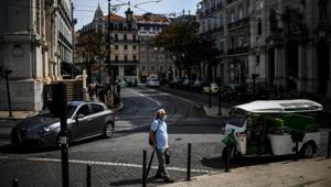 A man wearing a face mask crosses a street in Lisbon on September 22, 2020.(AFP photo) A man wearing a face mask crosses a street in Lisbon on September 22, 2020.(AFP photo)