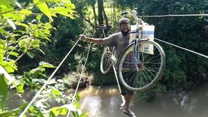The videos and photos showed women, elderly persons and youngsters dangerously balancing themselves on the 60 metre long rope while angry river flew below their feet. (HT Photo) The videos and photos showed women, elderly persons and youngsters dangerously balancing themselves on the 60 metre long rope while angry river flew below their feet. (HT Photo)